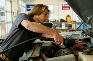 A Greater Peoria Works intern gets under the hood at Beachler's Auto.